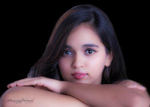 portrait shoot of a young girl with long dark hair and a pink lip