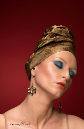 advertorial shoot of a woman with a gold turban and blue eyeshadow