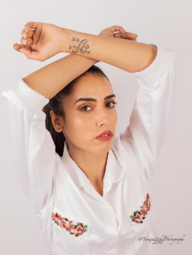 fashion shoot of a woman in a white shirt with a tattoo on her arm