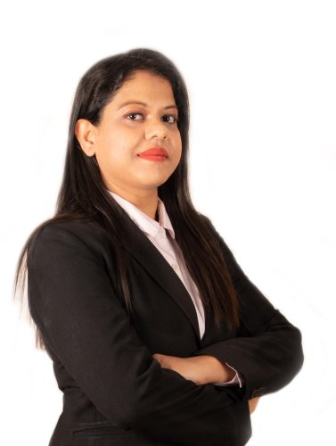 corporate headshot of a woman in a black suit with her arms crossed