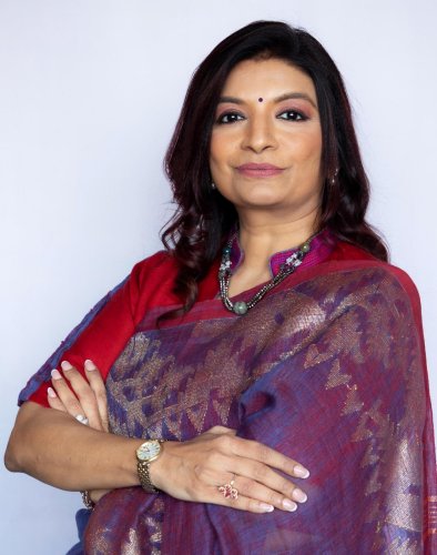 corporate headshot of a woman in a sari with her arms crossed