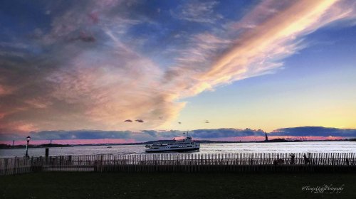 scenery of a boat in the water at sunset with a sky background