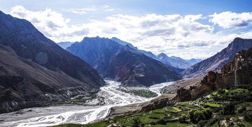 scenery of a valley with a river and mountains in the background