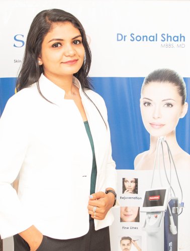 corporate headshot of a woman standing in front of a banner
