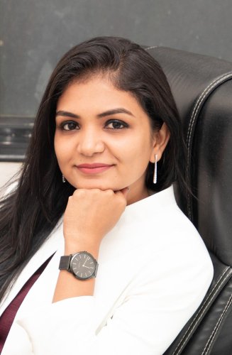 corporate headshot of a woman in a white blazer and a black watch
