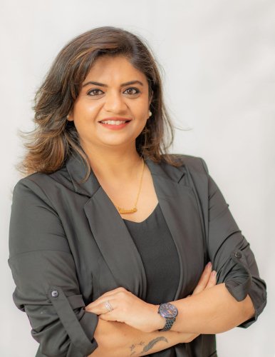 corporate headshot of a woman with a smile and a black blazer