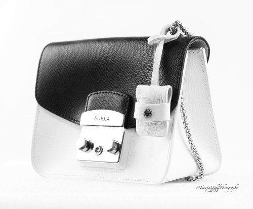 product shoot of a white and black purse with a chain