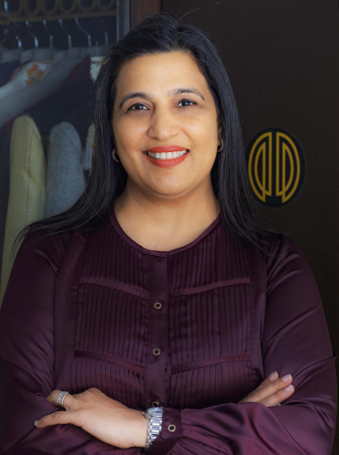 corporate headshot of a woman with long black hair and a purple shirt