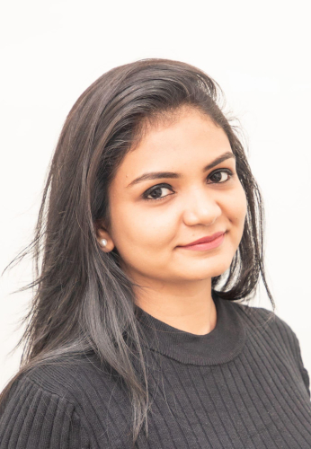 corporate headshot of a woman with long dark hair and a black sweater