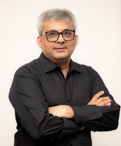 corporate headshot of a man with glasses and a black shirt