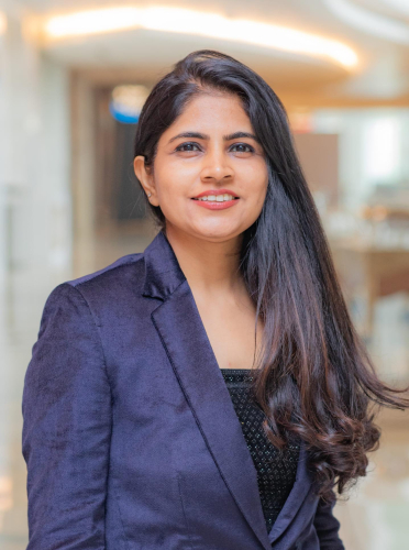 corporate headshot of a woman in a purple blazer