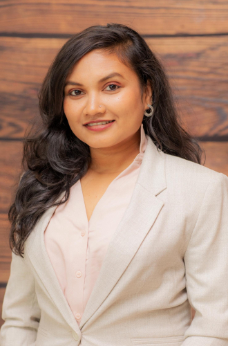 corporate headshot of a woman in a white suit and pink blouse