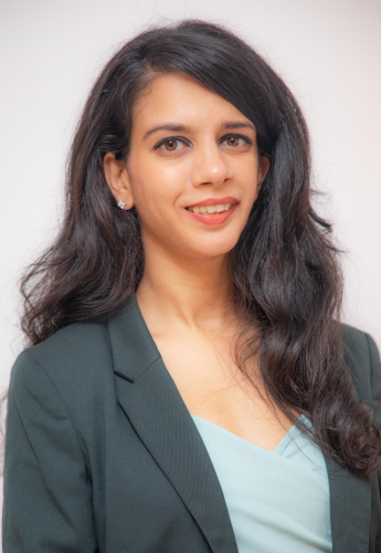 corporate headshot of a woman with long dark hair and a blue top