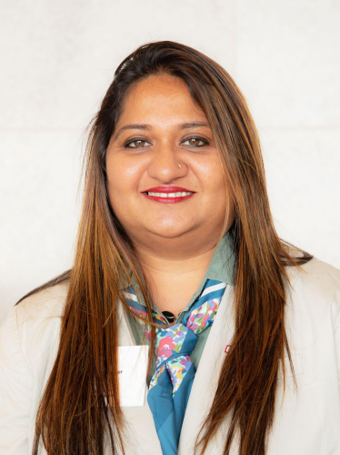 corporate headshot of a woman with long hair and a blue neck tie