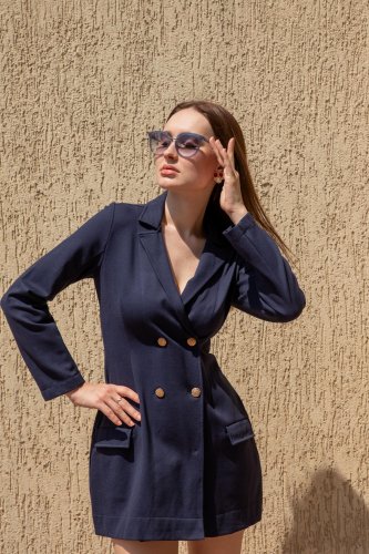 fashion shoot of a woman in a blue suit and sunglasses