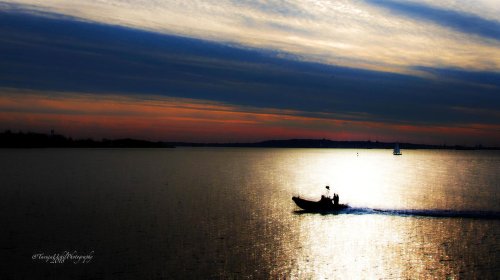 scenery of a boat sailing on a large body of water