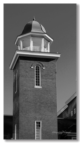 structure of a brick building with a clock tower and a steeple