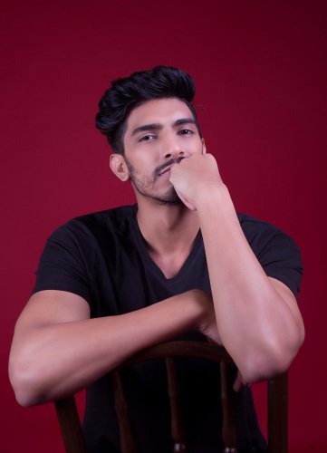 portrait shoot of a man sitting in a chair with his hand on his chin
