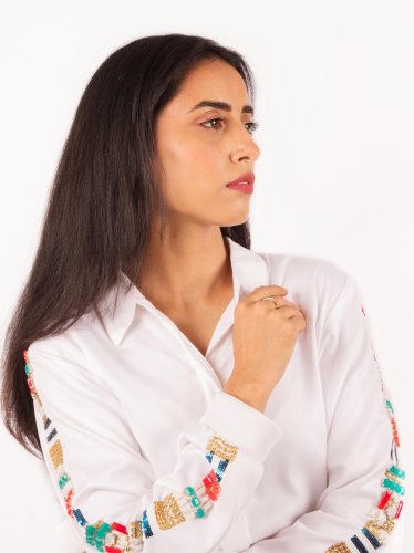 portrait shoot of a woman in a white shirt with a colorful embroidered sleeve