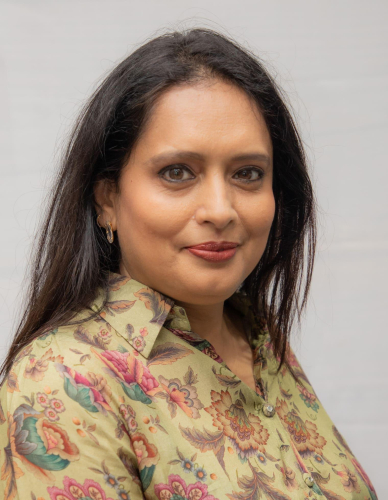 corporate headshot of a woman with long hair and a floral shirt