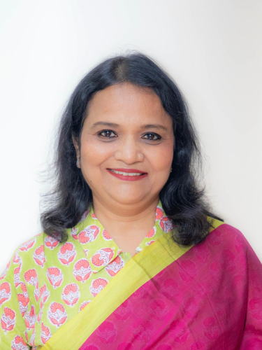 corporate headshot of a woman in a pink and green sari