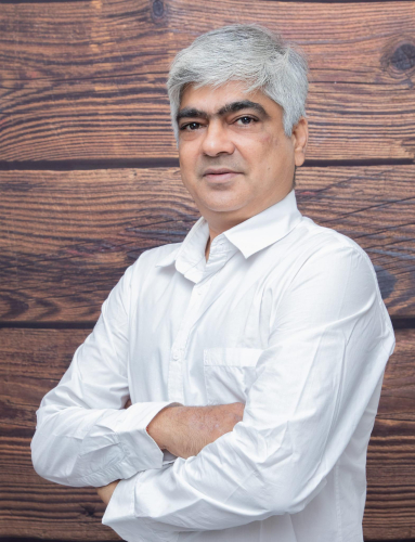 corporate headshot of a man with a white shirt and a wooden wall
