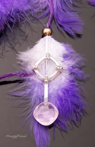 product shoot of a feathered object with a crystal in it