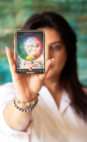 portrait shoot of a woman holding up a tarot deck