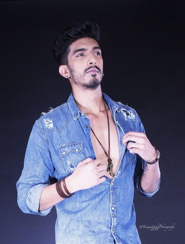 portrait shoot of a man in a denim shirt and a necklace