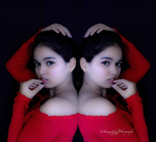 portrait shoot of a woman in a red dress with her hands on her head