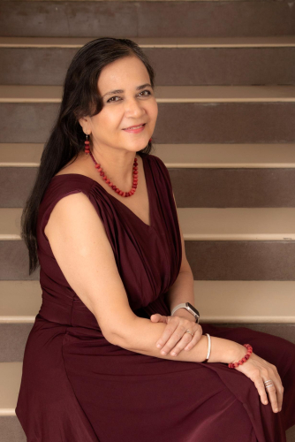 portrait shoot of a woman in a maroon dress sitting on a set of stairs