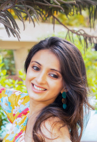 portrait shoot of a woman with long hair and earrings smiling