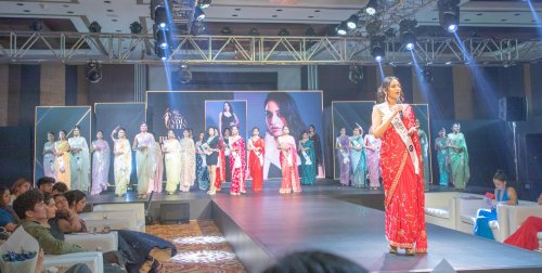 event picture of a woman in a red sari on a stage
