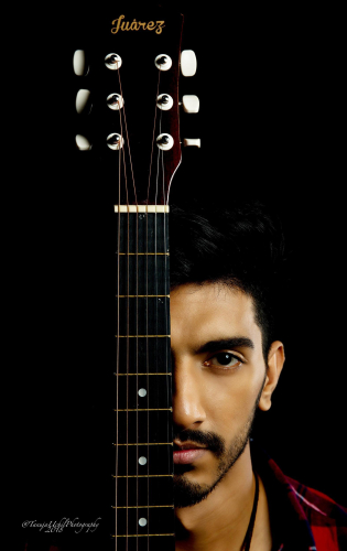 portrait shoot of a man with a guitar in front of his face