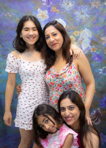 family portrait of three women posing for a picture in front of a painting