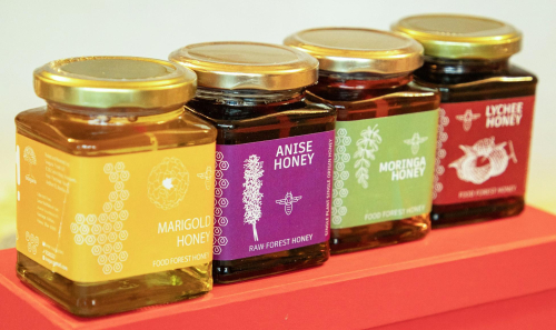 food pic of a row of honey jars on a red shelf