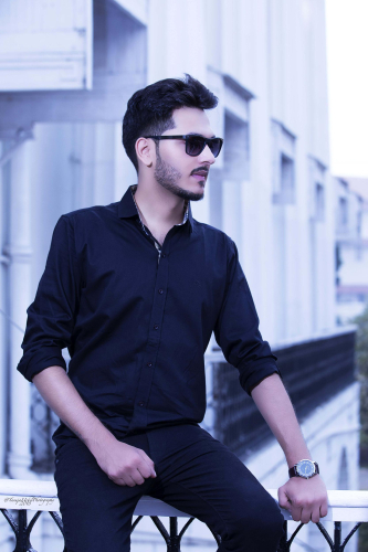 portrait shoot of a man in sunglasses sitting on a railing