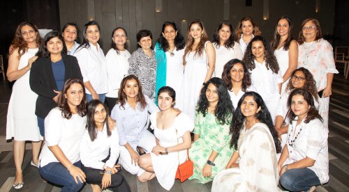 event picture of a group of women in white dresses posing for a picture