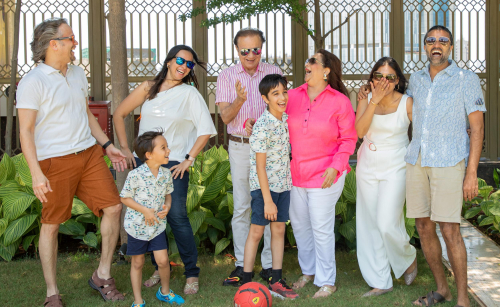 event picture of a family posing for a picture in front of a fence