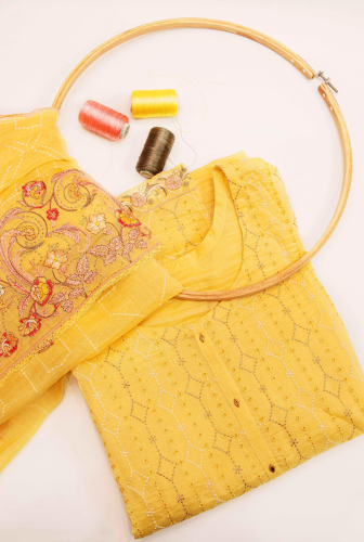 product shoot of a yellow sari with thread and thread spool